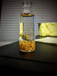 Gullflak flytende i en væske på kontoret mitt